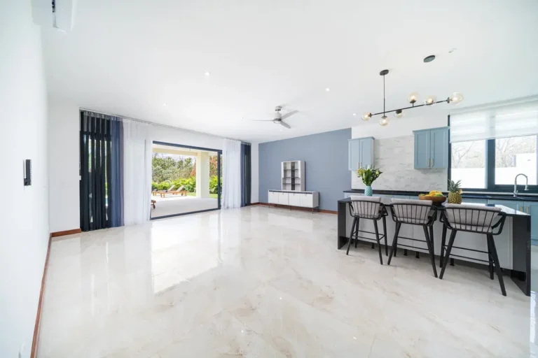 Open-plan living space with glossy porcelain floors and a kitchen bar.