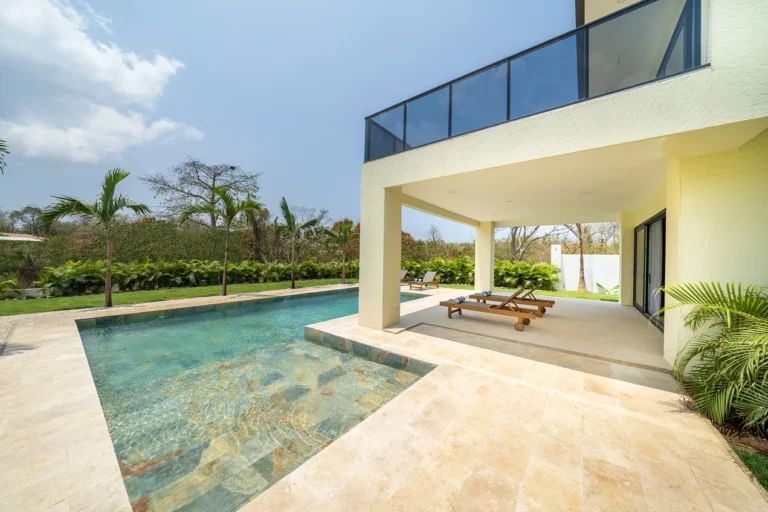 Pool and travertine terrace beneath the cantilevered upper balcony of Casa de Acero.