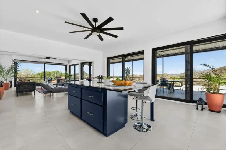 Kitchen island opening onto a living area with wide windows and mountain views.