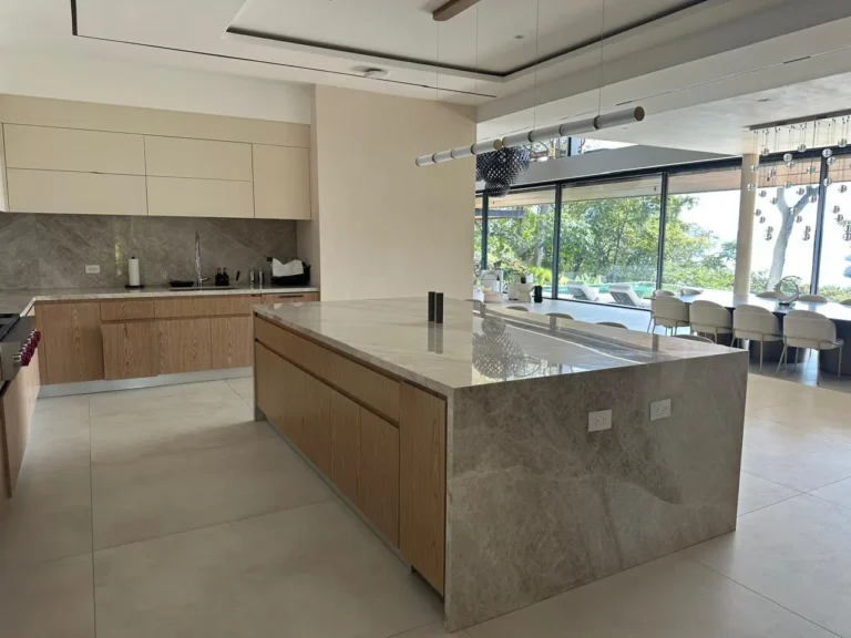 New kitchen with wood-front island and open view to the terrace, Escazú renovation