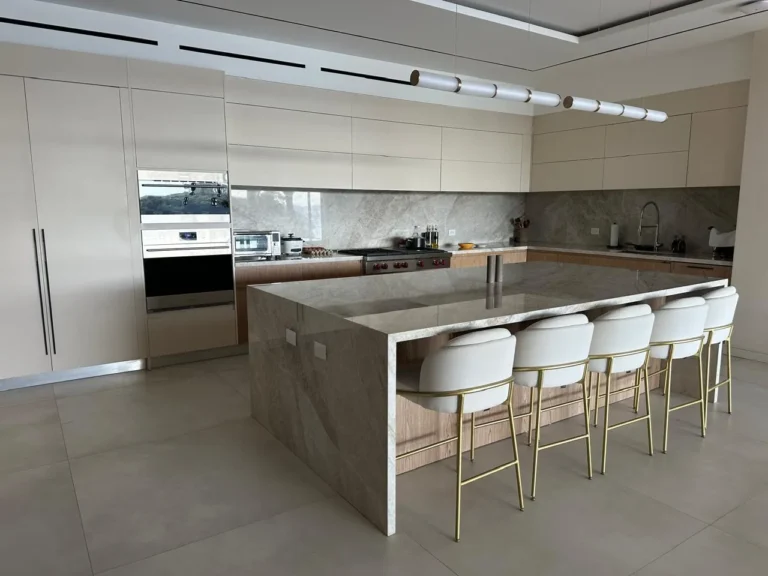 Renovated kitchen in Escazú with a marble waterfall island and bar seating