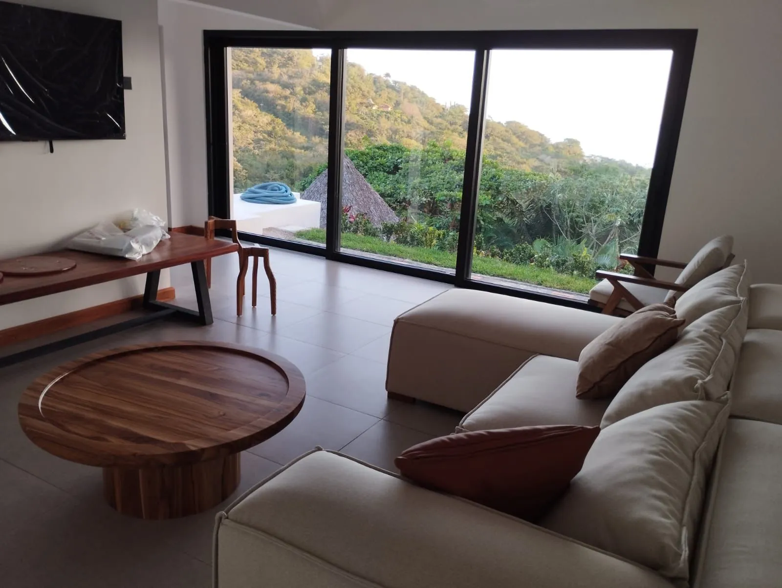 Renovated living room in Escazú with floor-to-ceiling glass and a hillside view