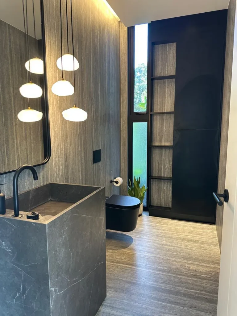 Powder room with a stone basin and pendant lights