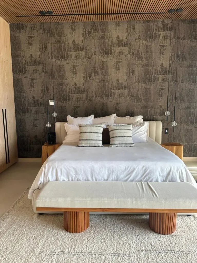 Primary bedroom with a textured feature wall in the Escazú renovation