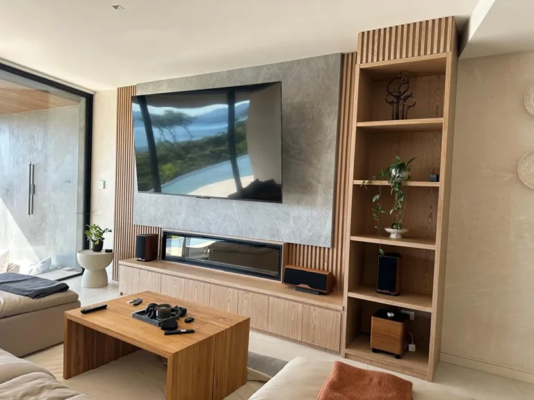 Living room TV wall in plaster with oak shelving, renovated home in Escazú