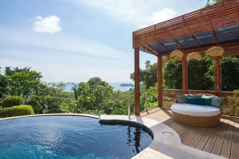 Plunge pool and shaded daybed overlooking the rainforest and Pacific islands.