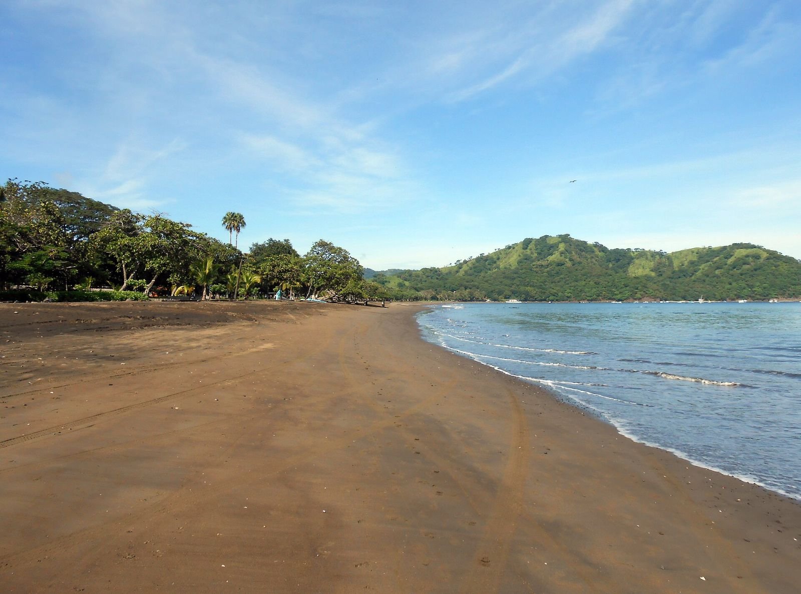 Dark-sand beach and calm bay at Playas del Coco in Guanacaste, Costa Rica.