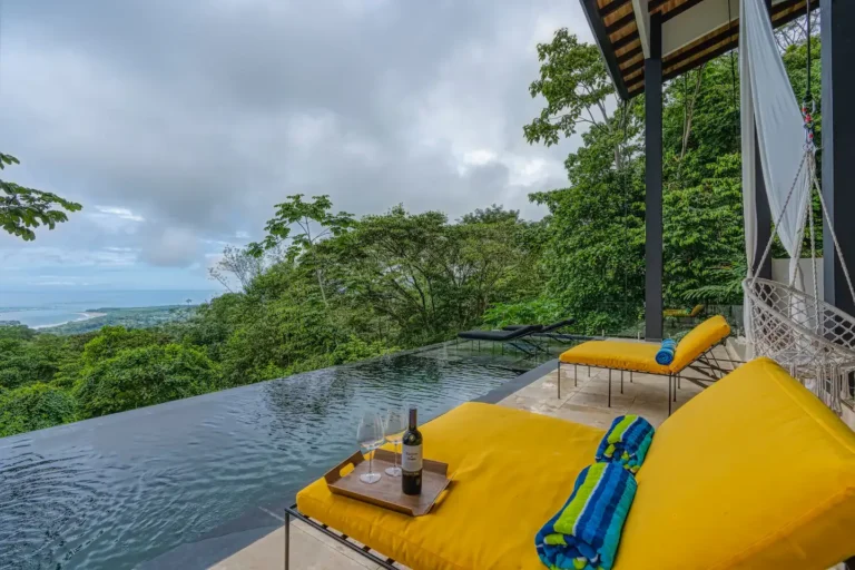 Infinity pool and daybed overlooking the jungle canopy toward the coast.
