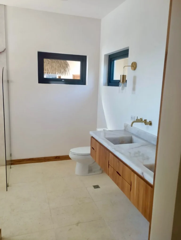 Vanity with a round mirror and pendant lights beside a wood door